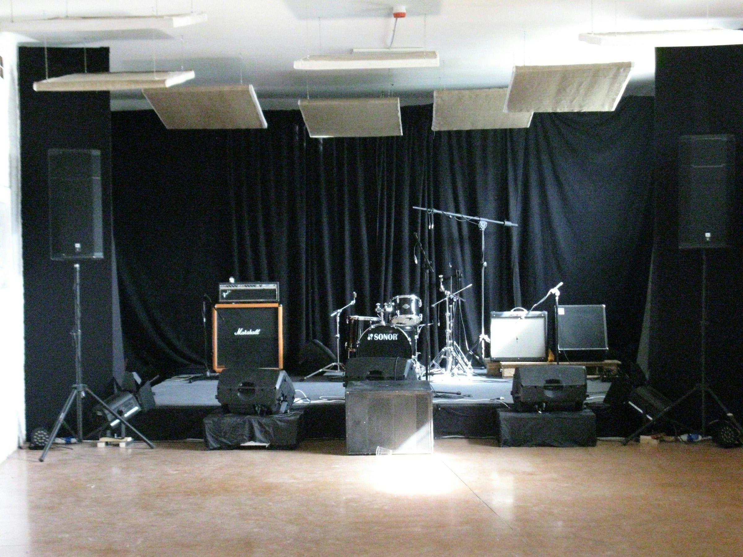 Stage with speaker stacks, backline, and a drum kit ready for a show